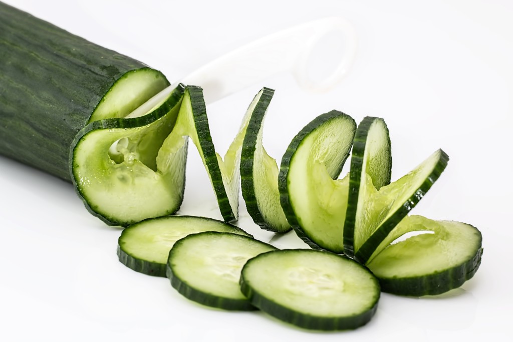 Frische Salatgurken, eine davon in Scheiben geschnitten