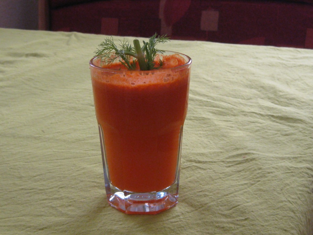 Hohes Glas mit frisch gepresstem Karottensaft auf einem Tisch